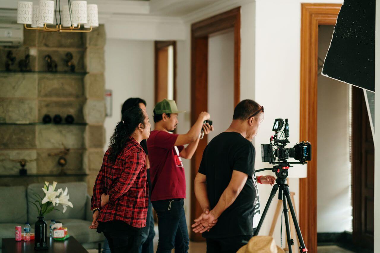 Filmteam bespricht die Aufnahme hinter der Kamera, Symbolbild für den Ablauf einer Videoproduktion